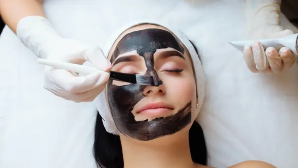 Zwart carbon masker wordt met een kwastje aangebracht voor een carbon laser peeling